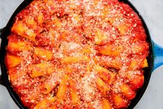 a skillet filled with pasta covered in sauce and parmesan sprinkles