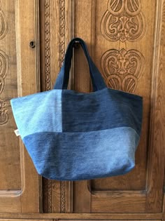 a denim bag hanging on a wooden door