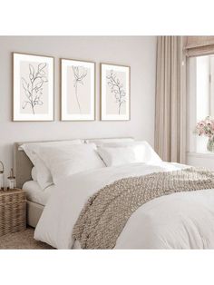 a bedroom with two pictures on the wall above the bed and a wicker basket