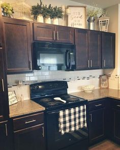 a kitchen with black and white checkered table cloth on the stove top, brown cabinets