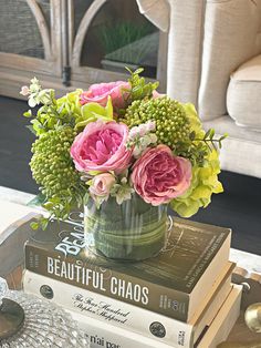 a vase filled with pink and green flowers sitting on top of two bookends