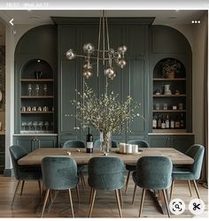 the dining room table is surrounded by blue chairs and green cupboards with silver balls hanging from them