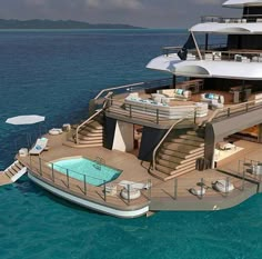 a large boat floating on top of the ocean next to a dock with lounge chairs