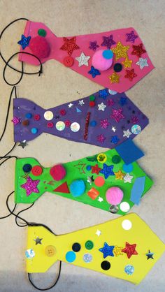 four different colored pieces of paper with buttons and sequins on them sitting next to each other