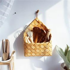 a basket with utensils hanging on the wall