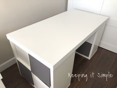 a white desk sitting on top of a hard wood floor next to a wall mounted cabinet