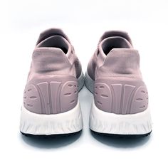 a pair of pink sneakers with white soles on a white surface, viewed from above