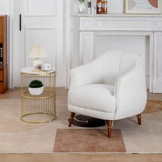 a living room with a white chair and a gold coffee table in front of a fireplace