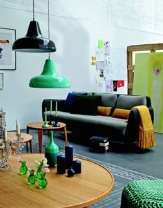 a living room filled with lots of furniture and colorful lights hanging from the ceiling above