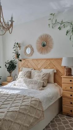 a bedroom with a bed, dresser and chandelier hanging from the ceiling in front of a window