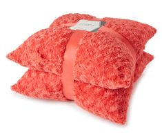 a red pillow with a bow on the front and back of it, sitting against a white background