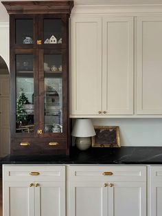 a kitchen with white cabinets and black counter tops