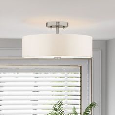 a lamp that is on above a window sill in a room with white blinds