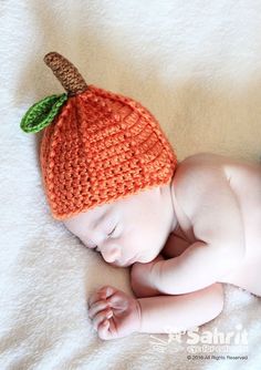 a newborn baby wearing an orange knitted hat