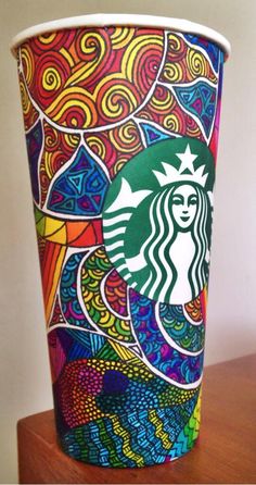 a starbucks cup with an artistic design on it