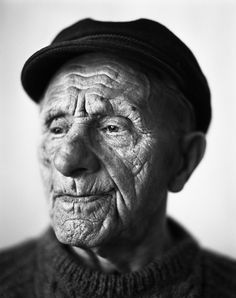 an old man wearing a hat and sweater