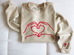 Heart Shaped Hands Sweatshirt, Heart Sweater, Valentines Sweatshirt, Swiftie Shirt, Valentines Day gifts, gifts For Her, Choose Your Colors *Text colors are shown in product photos. If a text color is not indicated, the text will be created in the color shown on the product photo.   *True to size Unisex adult fit. *50% Cotton 50% Polyester *SEE PHOTOS FOR SIZING CHART *Only one text color can be chosen per sweatshirt. Valentine's Day Gift Sweatshirt, Casual Heart Graphic Sweatshirt Gift, Valentine's Day Cotton Sweatshirt Gift, Valentine's Day Gift Cotton Sweatshirt, Long Sleeve T-shirt With Heart Graphic For Gift, Heart Graphic Long Sleeve Top As Gift, Heart Print Crew Neck Top As Gift, Long Sleeve Tops With Heart Graphic For Gift, Valentine's Day Gift Top With Long Sleeves