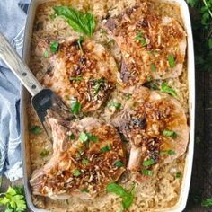 pork chops and rice in a casserole dish with parsley on the side