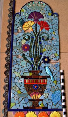 a stained glass window with flowers and birds on the bottom, next to a marker