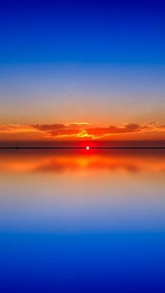 the sun is setting over the water and reflecting it's reflection in the water