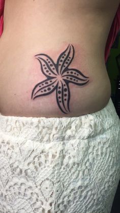 a woman's stomach with a black and white flower tattoo on her lower back