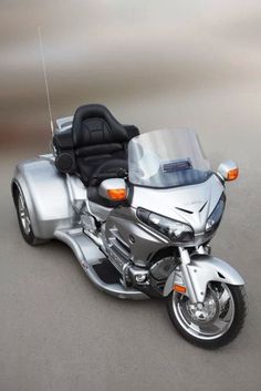 a silver motorcycle parked on top of a sandy beach