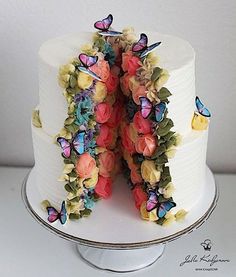 the cake is decorated with butterflies and flowers