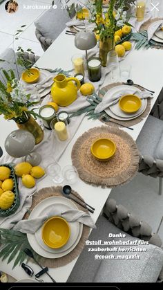 the table is set with yellow dishes and place settings for two people to sit at