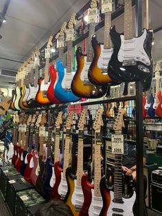 many guitars are on display in a store