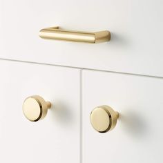 a white cabinet with gold handles and knobs