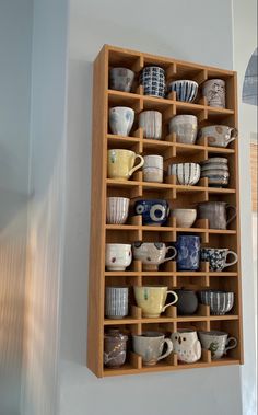 a wooden shelf filled with lots of cups