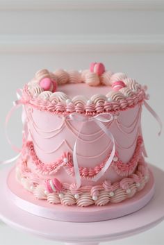 a pink cake decorated with hearts and ribbons