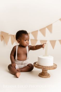 a baby sitting on the floor with a cake