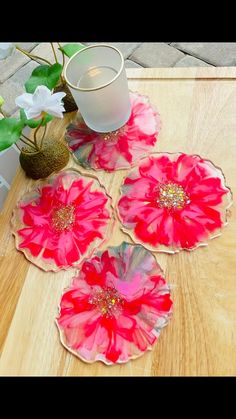 three pink flowers sitting on top of a wooden table