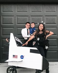 two adults and a child are posing in front of an airplane