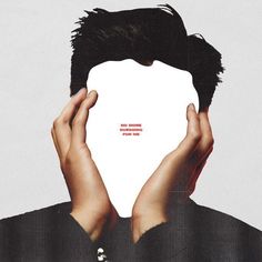 two hands covering the face of a man's head with an advertise on it