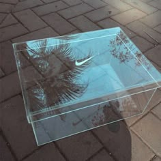 a clear box sitting on top of a brick sidewalk