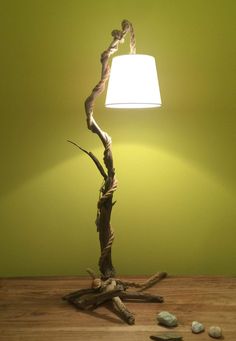 a lamp that is sitting on top of a wooden table in front of a green wall