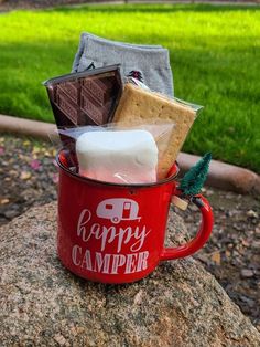 a red camper mug filled with marshmallows, cookies and other items