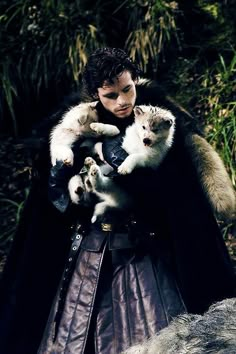 three people dressed in medieval costumes holding cats