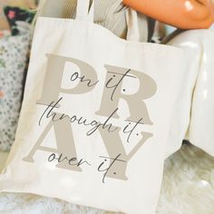 a person holding a tote bag that says, on it through it over it