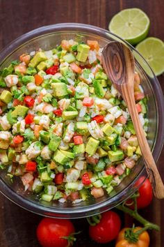 a salad with shrimp, avocado, tomatoes and cilantro in a glass bowl