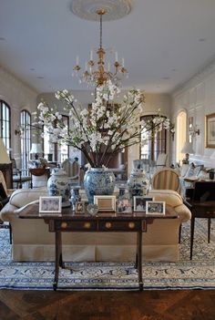 a living room filled with furniture and a large vase on top of a coffee table