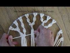 a person is making a piece of string art with white yarn on a wooden table