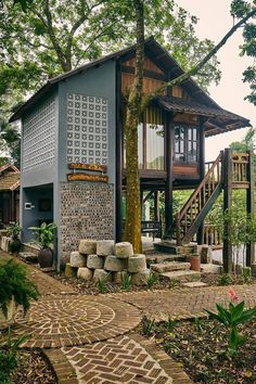 a small house sitting in the middle of a forest next to a tree and stairs