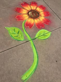 a drawing of a flower on the ground with colored chalk and crayon markers