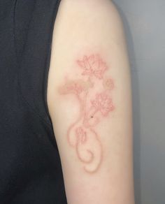 a woman with a tattoo on her arm that has pink flowers in the shape of a vase