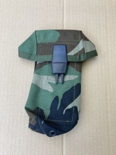 a green and blue camouflaged pouch with a clip on the side that is attached to it