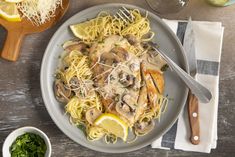 a plate of pasta with mushrooms and lemons