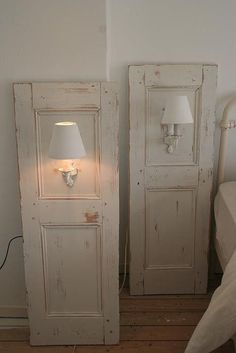 two white doors sitting next to each other in a room with a lamp on top of them